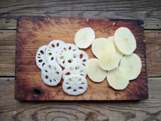 家庭版自制烤鱼,土豆和藕洗净去皮切厚片。