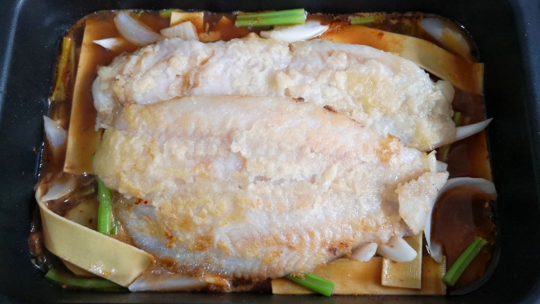 家庭版自制烤鱼,在配菜上放上煎好的鱼。