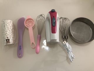 纸杯蛋糕,准备好所需工具：从左至右分别是纸杯，刮刀，蛋清分离器，手动打蛋器，电动打蛋器，面粉筛。