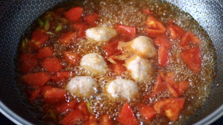 金针菇墨鱼丸子汤,大火煮沸后，继续煮至番茄软烂入味。