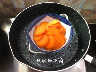 胡萝卜粉丝酸菜肉末包子,胡萝卜去皮后切成薄片，然后装入盘子里隔水蒸熟，上汽后大约蒸15分钟，蒸好的胡萝卜放置一旁冷却后备用