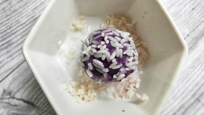 奶香紫薯糯米球,揉成团的紫薯在泡好的糯米里滚一圈，让全身都沾上糯米粒。