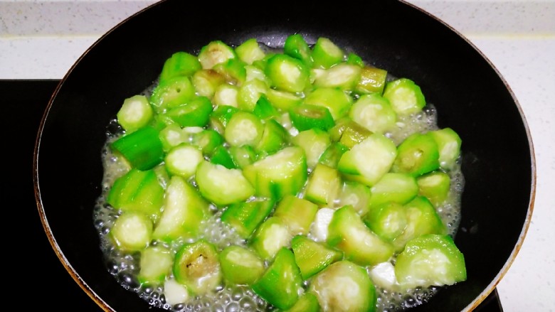丝瓜菜拌南瓜手擀面,炒至丝瓜变软，放入适量盐。