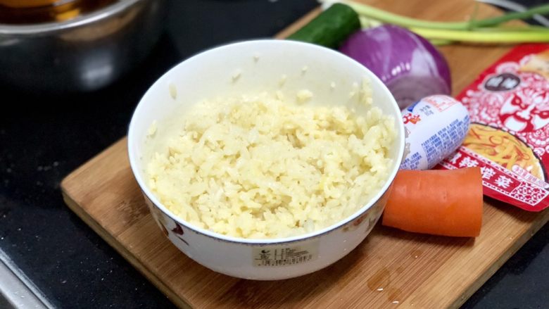五彩杂蔬炒饭,鸡蛋打入米饭中，抓拌均匀，让蛋液包裹每一粒米饭