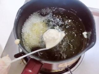 土豆虾球（天妇罗土豆虾球）,油锅烧至5成热，用勺子挖出虾球，逐一放入到油锅中。