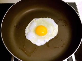 韩式石锅拌饭,把炒锅烧热后刷一层玉米油，打入鸡蛋，煎制一个溏心蛋