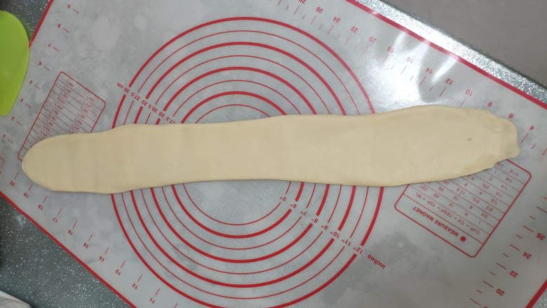 一次发酵手撕吐司面包,第二次擀卷。擀的过程中如果一次无法将其擀很长可以稍微等等再擀下一次，不要硬擀将其擀破，⭐擀50厘米左右