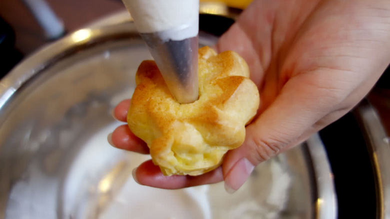 奶油泡芙,在底部用手指或直接用裱花嘴插入底部，在里面打入馅料就可以吃了。
