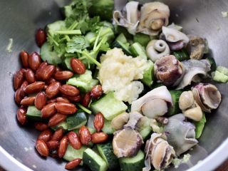 温拌海螺,取一个大一点的容器，把黄瓜和花生米，海螺和蒜泥，香菜放入盆里。
