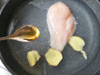柠檬手撕鸡,锅中适量水下鸡胸肉，加姜片和料酒，煮熟。