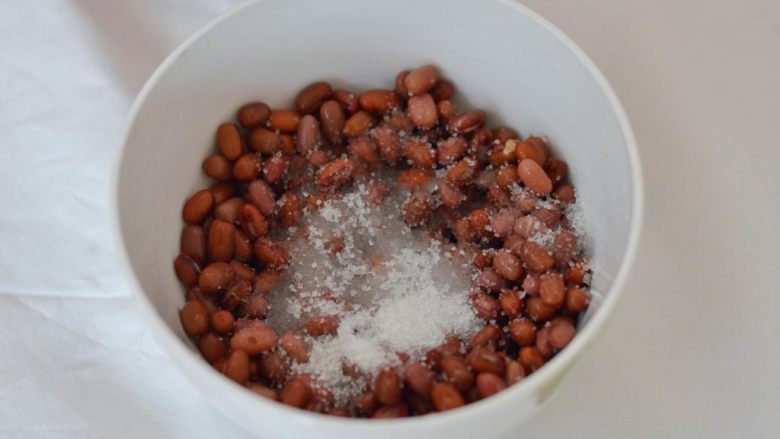 蜜豆山药糕,泡好的红豆明显比之前变得膨胀，将红豆捞出装到小碗里，表面放上一点砂糖
