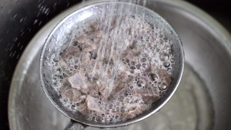 猪肝茼蒿粥,把切丁的猪肝，放入漏勺里，用自来水反复冲洗猪肝的血水。