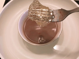 巧克力慕斯蛋糕,将泡软的吉利丁片放入热可可牛奶中。