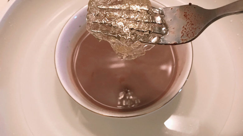巧克力慕斯蛋糕,将泡软的吉利丁片放入热可可牛奶中。
