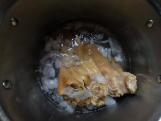凉拌红油猪耳朵,把煮好的猪耳朵捞出，放入加冰块的水中过凉。