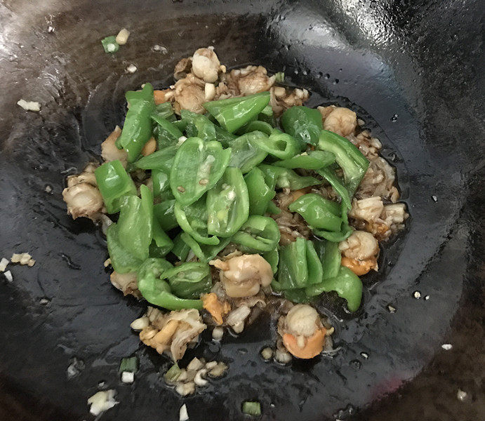 冬日暖心菜 青椒爆炒扇贝肉,接着倒入调好的烧汁和青椒翻炒均匀