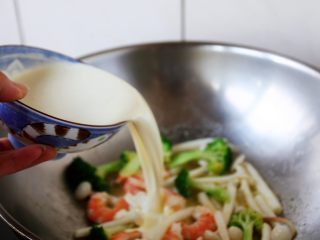 虾仁菌菇白汁意面,倒入淡奶油和牛奶的混合液体。