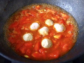 咖喱番茄丸子盖浇饭,锅中倒入适量的清水煮沸后，放入鸡肉丸子和墨鱼丸子。