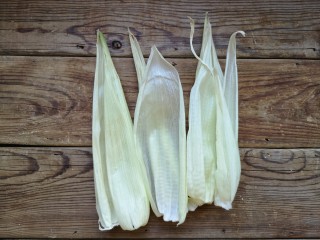 玉米粑粑,玉米去皮，但内皮不要扔，用清水把玉米叶冲洗干净，放在一旁控干水分备用。