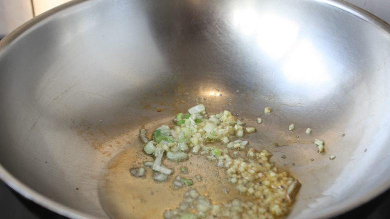 鸡米炒毛豆,热锅凉油，放入葱花蒜末炒出香味。