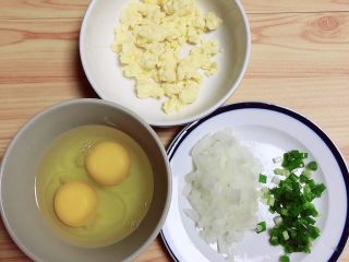 鸡蛋抱饺,煎饺子时，准备其他食材，将洋葱、小葱切碎备用。鸡蛋打入碗中。