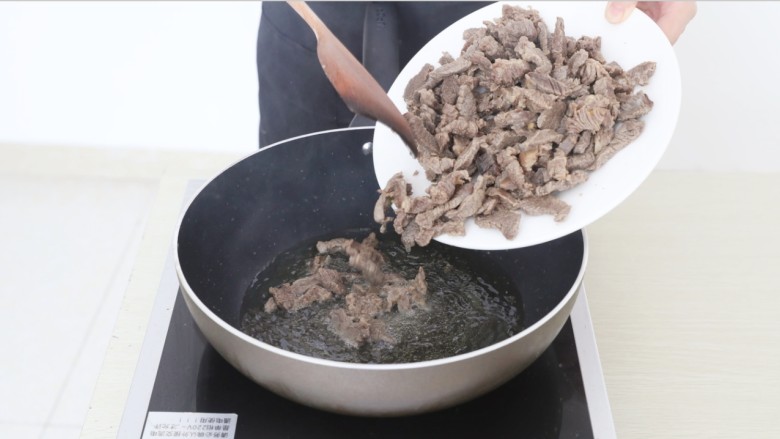 麻辣牦牛肉,锅中放油，倒入焯好水的牦牛肉，当肉丝煸炒至表面略微焦黄后盛出。