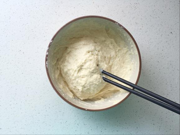 红枣牛奶发糕,酵母化开后倒入面粉中，用筷子顺时针搅拌均匀；