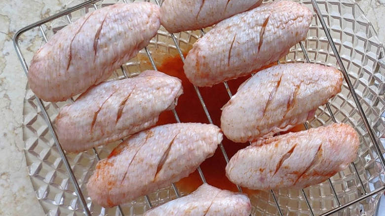 蜜汁烤鸡翅中,烤制前沥一下多余的调料汁，将鸡翅放在网架上或者铺了油纸的托盘上。