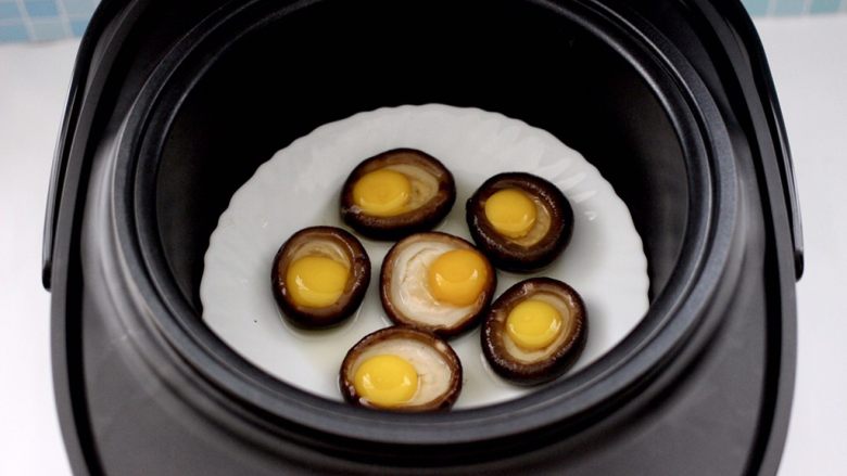香菇虾仁酿鹌鹑蛋,最后把装香菇酿鹌鹑蛋的盘子放入甑锅中。