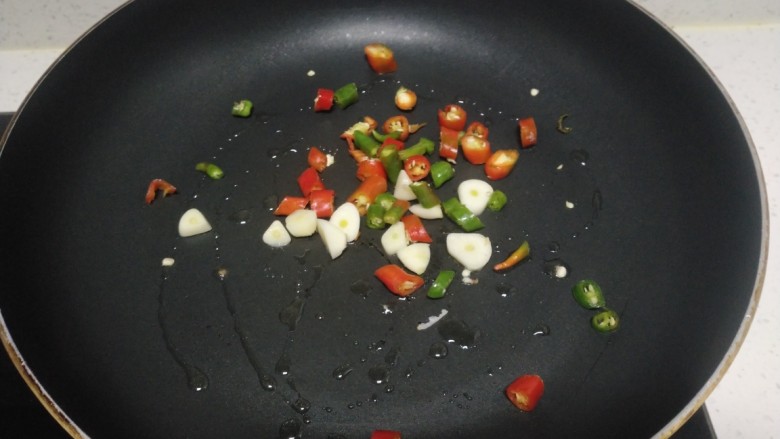 尖椒炒洋葱、黄瓜,锅中放入适量油，炒香蒜瓣、尖椒