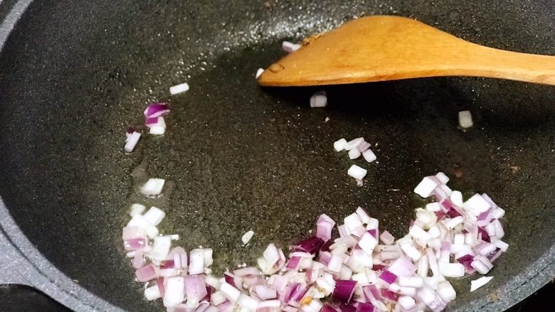 酸豆角炒饭,盛出豆腐丁后，锅中放入洋葱翻炒至透明；