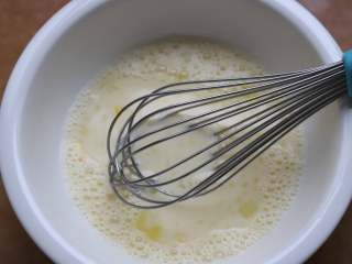 快手松饼,用手动打蛋器多搅拌一会儿，或者换成电动的打蛋器，搅打两三分钟，将蛋液与牛奶，砂糖充分搅拌均匀，砂糖要全部搅融化。