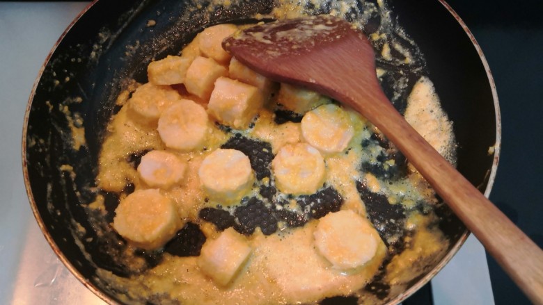 咸蛋黄焗山药,用铲子翻拌均匀，让每一块山药都裹上咸蛋黄