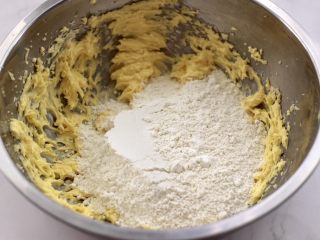 KT黄油蛋黄饼干,这个时候加入低筋粉，要根据面团的粘手程度，留10克面粉来调整，不能太粘手，也不能太干了。