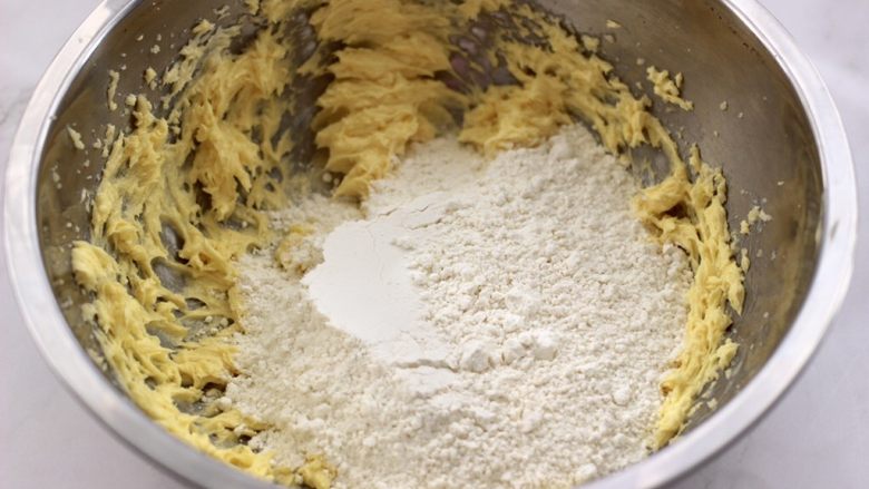 KT黄油蛋黄饼干,这个时候加入低筋粉，要根据面团的粘手程度，留10克面粉来调整，不能太粘手，也不能太干了。