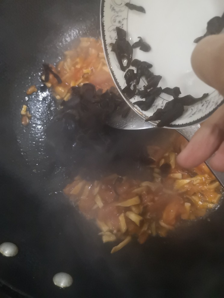 菌菇豆腐汤,加入木耳翻炒两分钟