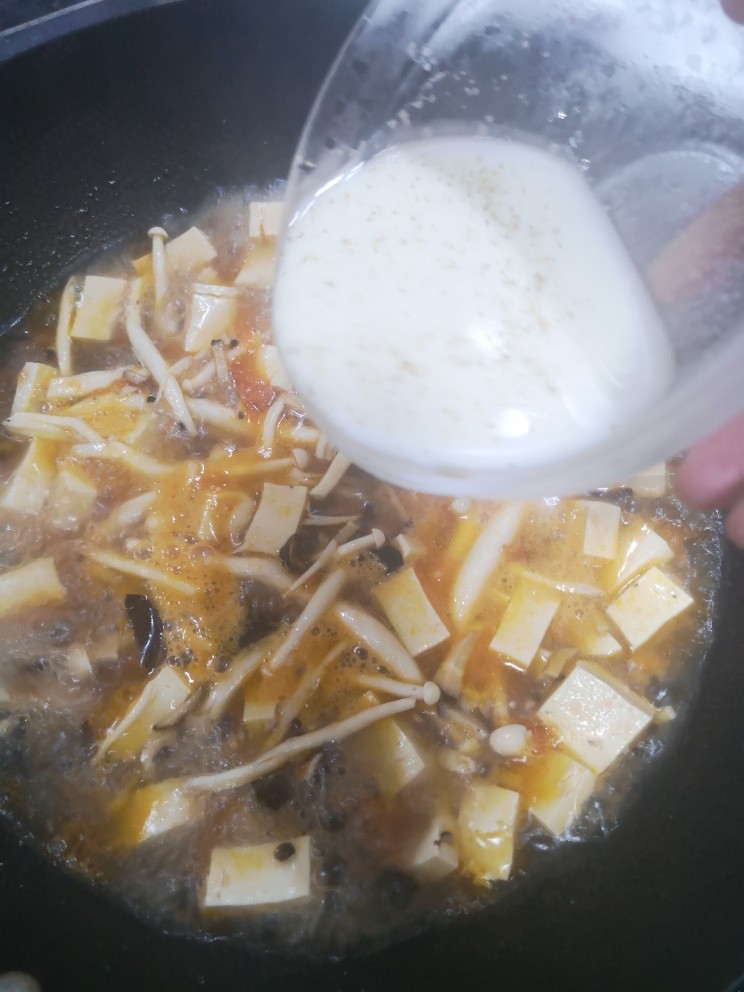 菌菇豆腐汤,加入海香菇汤烧开后，把淀粉和胡椒粉拌好的水倒进锅里
