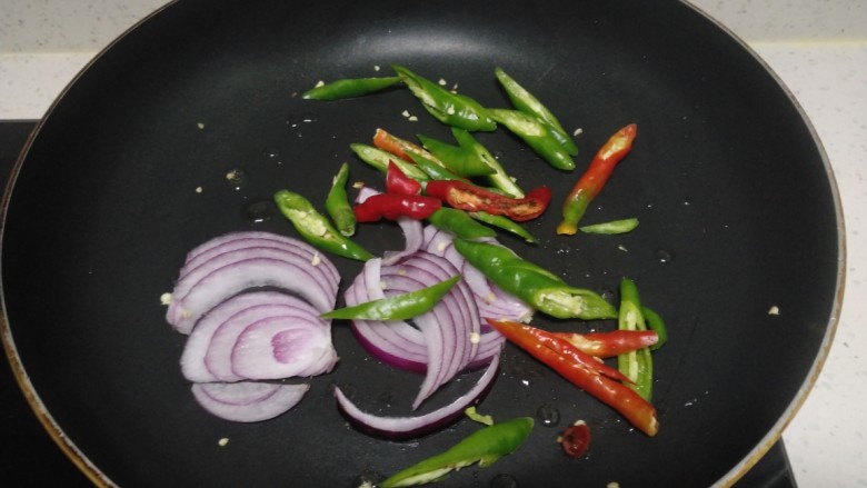 尖椒炒西红柿、小白菜,锅中放入适量油，炒香尖椒、洋葱丝