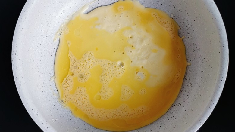 香蕉奶酪饼,不粘锅刷一层油，倒入二分之一蛋液