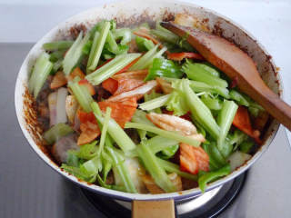 重庆鸡公煲,倒入腌制好的鸡块翻炒，加入适量的黄酒和生抽。炒至水分收干。
