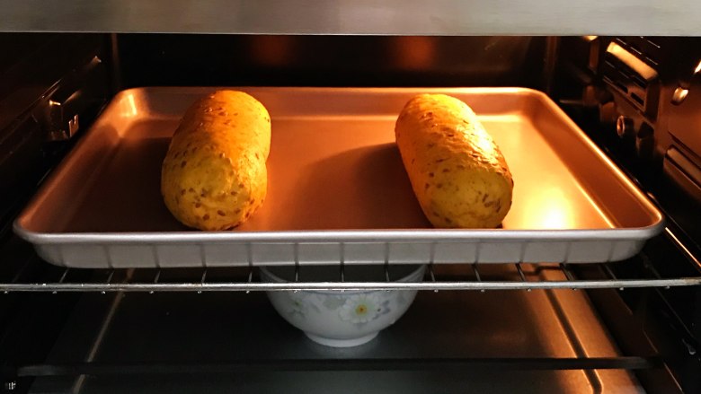 亚麻籽南瓜软欧,把面团放入烤箱内进行二发，在烤箱下层放碗热水增加温度和湿度。