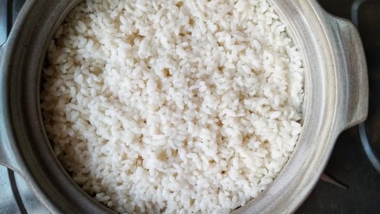 腊味煲仔饭,米饭煮到八成熟后开盖看一下。