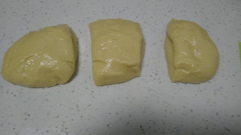手撕面包,倒入操作台揉搓，使黄油和面粉充分融合，搓成长条平均分成3份