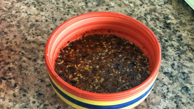 麻辣拌面,过滤掉油里的香料，把油倒入辣椒粉中，用勺子拌匀。
 