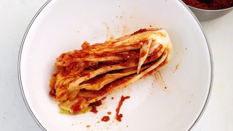 韩式辣白菜,取一块腌好的白菜，在每个叶片里面抹上一层厚厚的辣酱