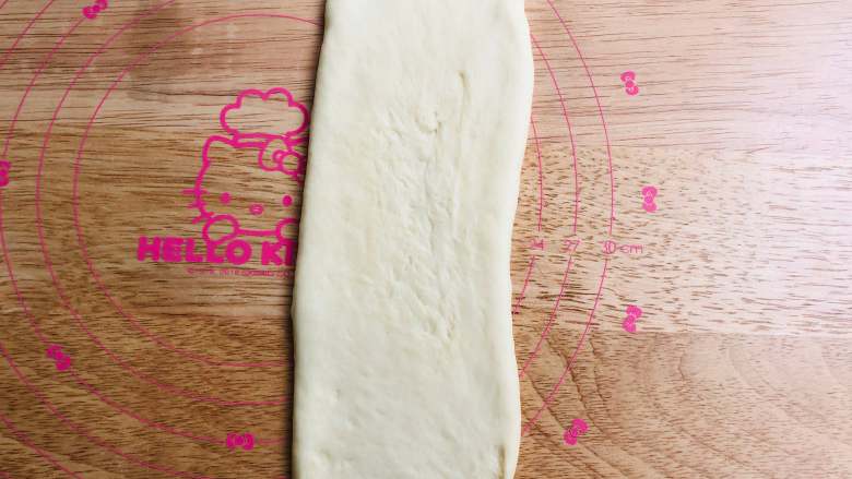手撕面包,取一个圆形面团先将的两边轻轻地收一下，变成椭圆形，再将面团擀成一个长约30厘米的长条形，翻面