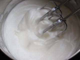 蜜豆蛋糕卷,用电动打蛋器来打发蛋白，分三次往蛋白中加入细砂糖，第一次加入在蛋白出现大炮的时候，第二次加入在蛋白出现细腻的气泡的时候，第三次加入在蛋白霜出现轻微的纹路的时候，此时可以先预热烤箱。
