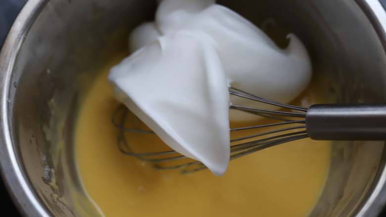 蜜豆蛋糕卷,先取三分之一蛋白霜，加入到蛋黄糊中，上下翻拌均匀，不要胡乱搅拌。