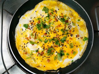 杂粮煎饼,在蛋液完全凝固前撒上榨菜碎，香菜，香葱和黑芝麻。