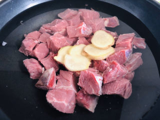 红烧牛肉这样做，好吃到停不下来！,牛肉冷水入锅，放入生姜片和料酒，大火绰一下。